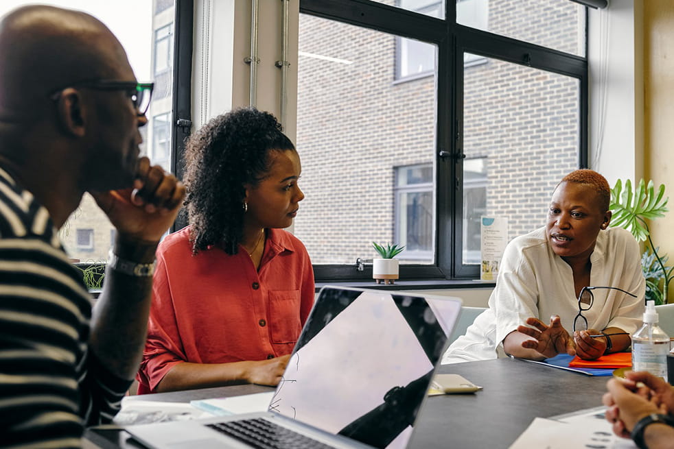A man and two women discussing work