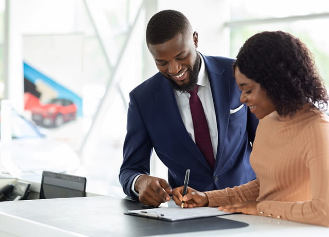 Man helping woman sign a contract